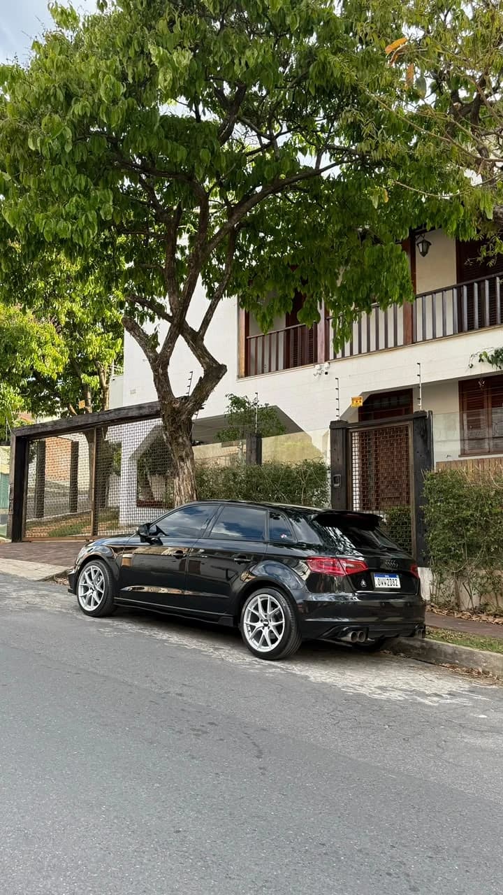 Audi A3 Sportback preto estacionado, vista lateral traseira